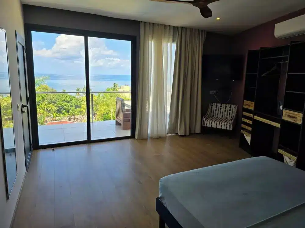 Chambre 4 de la Villa Sophie à Nosy Be, avec baie vitrée donnant sur une terrasse et vue sur la mer